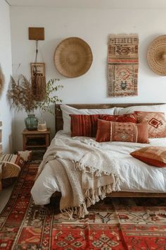 a bed with lots of pillows on top of it in a room filled with rugs