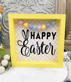 a yellow frame with the words happy easter on it next to other decorations and flowers