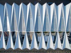 an aerial view of the exterior of a building with many triangular shaped white panels on it