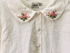 a white shirt with pink flowers on it