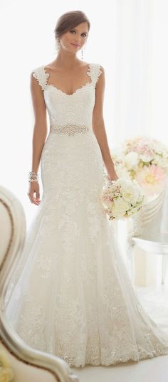 a woman in a wedding dress standing next to a chair