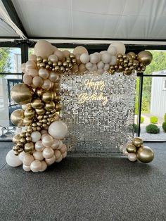 a balloon arch with gold and white balloons