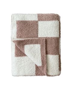 a brown and white checkered blanket on top of a bed next to a pillow