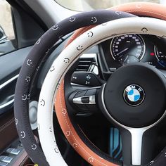 the steering wheel cover is decorated with black, white and orange embellishments