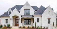 a large white brick house with two story windows