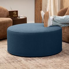 a person laying on top of a blue ottoman