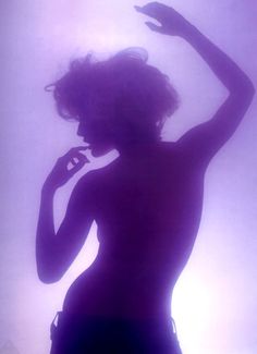 the silhouette of a woman with her arms raised