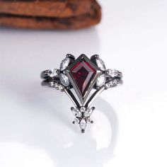 Black Magic Brilliance: The Nora Ring set. Handcrafted in black gold vermeil, this ring set is a dramatic stage for with a captivating kite cut 1.5-carat garnet center. The fiery contrast is a guaranteed conversation starter (sizes 3.75-14.25). ✦ DETAILS ✦ ✧ Handcrafted  ✧ 1.5 Carat center stone ✧ Natural crystals  ✧ Sizes 3.75-14.25 US ✧ This ring will arrive ready to gift in a Kherish Jewelry Pouch. ✧ PRE-ORDER: Items that are preorder only will ship within 10-15 business days.  You will recei Mystical Wedding, Bloodstone Ring, Gothic Engagement Ring, Black Gold Ring, Timeless Ring, Promise Ring For Her, Garnet Crystal, Silver Engagement Ring, Promise Rings For Her