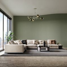 a modern living room with green wallpaper and white couches in front of a large window