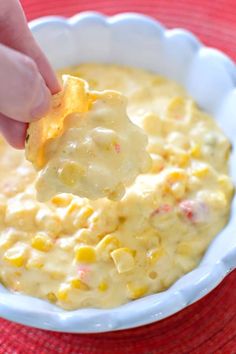 the dip is being served in a bowl with tortilla chips