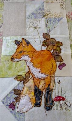 a close up of a patchwork quilt with a fox on it's side