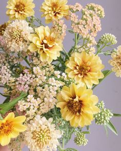 a vase filled with lots of yellow and white flowers