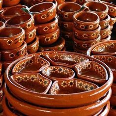 many brown pots are stacked on top of each other