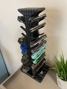 a stack of scissors sitting on top of a table next to a potted plant