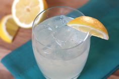 a glass filled with ice and lemon on top of a table