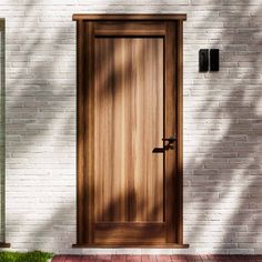 a wooden door on a white brick wall