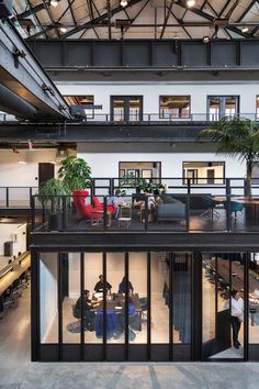 an office building with lots of windows and people sitting at tables in the middle of it