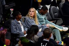 two women sitting next to each other in front of a group of people at a basketball game