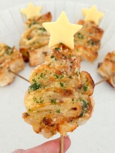 a person is holding up some food on a stick with cheese and parmesan sprinkles