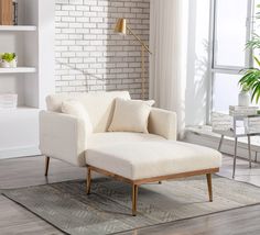 a living room with a white couch and brick wall in the background, along with a rug on the floor