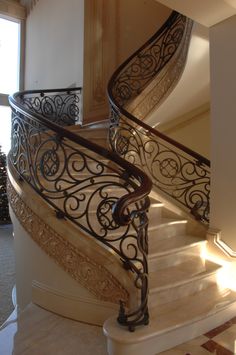 a spiral staircase with wrought iron railing and handrail