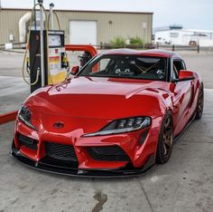 a red sports car parked at a gas station