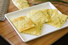 some food is on a white plate with a cutting board and knife in the background