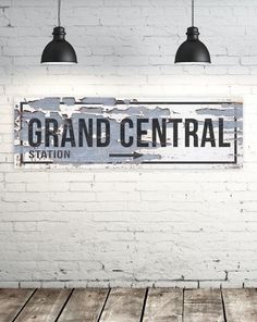 a white brick wall with a sign that says grand central station hanging from the ceiling