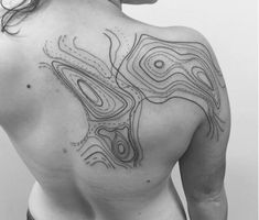 the back of a woman's upper half with lines and dots on her chest