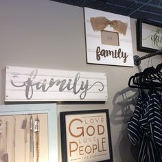 there are many signs on the wall with clothes hanging from it's hangers