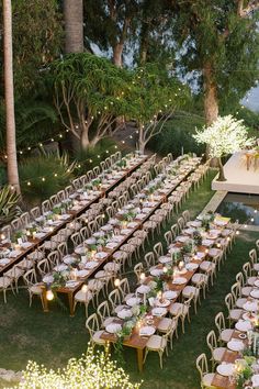 an outdoor dinner setup with long tables and chairs