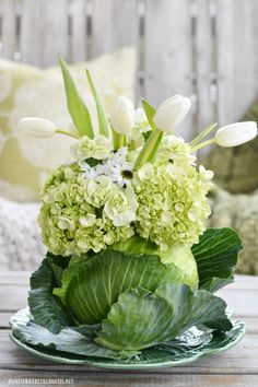 a vase filled with green and white flowers