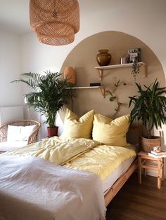 a bed with two plants on the headboard and some shelves in the wall above it