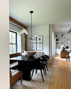 a dining room table and chairs in front of a large window with lots of light