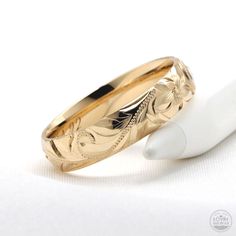 two gold wedding rings sitting next to each other on top of a white tablecloth