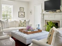 a living room filled with furniture and a flat screen tv mounted on the wall above a fireplace