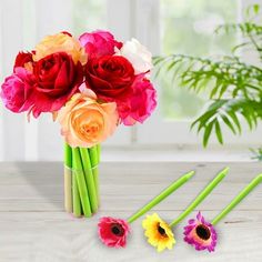 colorful flowers in a vase on a table with green stems and three different colored flowers