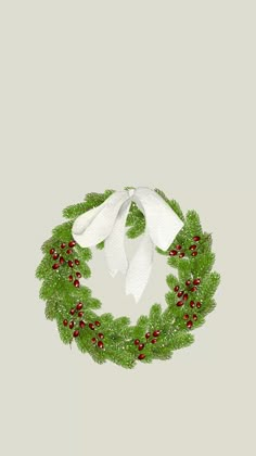 a christmas wreath with white bow and red berries