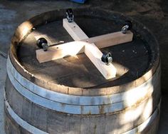 a wooden cross sitting on top of a barrel