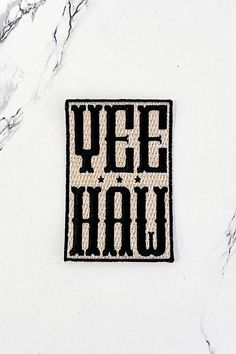 a black and white patch with the words yee hau in large letters on it