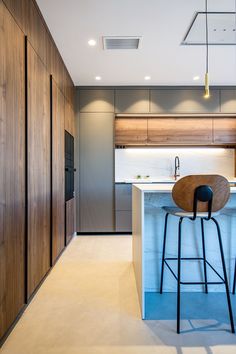 a modern kitchen with an island and bar stools