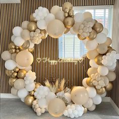 a white and gold balloon arch with balloons