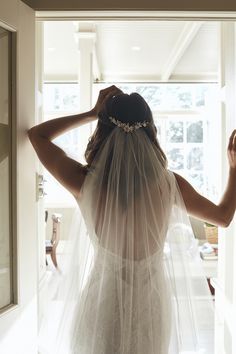 the back of a bride's dress, with her veil draped over her head