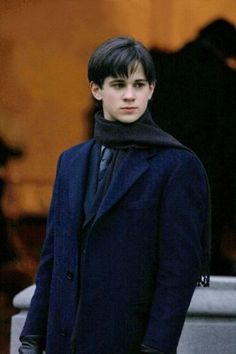 the young man is wearing a coat and scarf