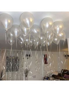 some white balloons are hanging from the ceiling