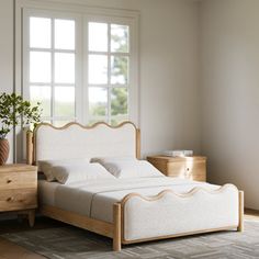 a white bed sitting next to a window in a bedroom