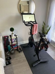 a bike is parked in front of a mirror on the wall next to a couch