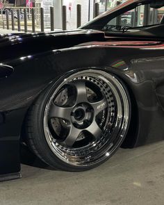 a black car with chrome rims parked on the street