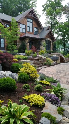 a large house with lots of plants and rocks in the front yard, along with steps leading up to it