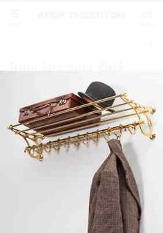 a coat rack with a hat and suit case hanging from it's side on a wall